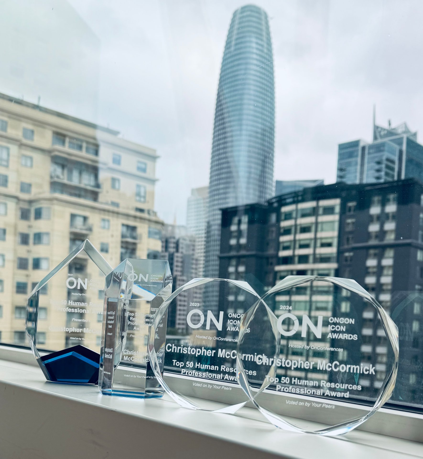 OnCon ICON Award trophies for Christopher McCormick with the San Francisco skyline behind them